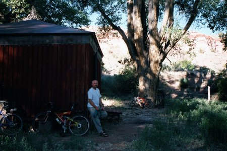 Rob leaning against Gateway Hut, both in  shadow.